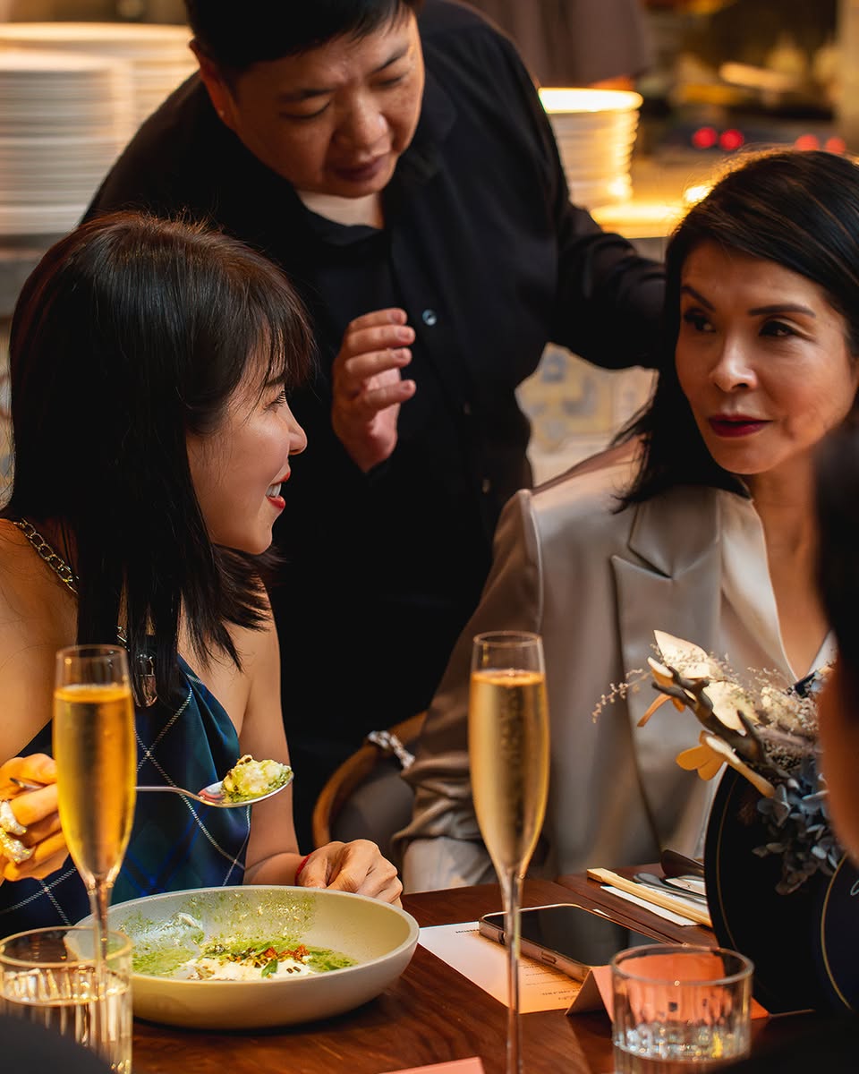 The culinary team presenting a dish to appreciative guests