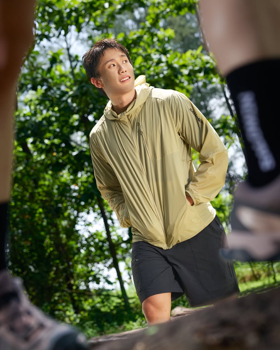 Model wearing ZONAR hooded windbreaker in forest setting