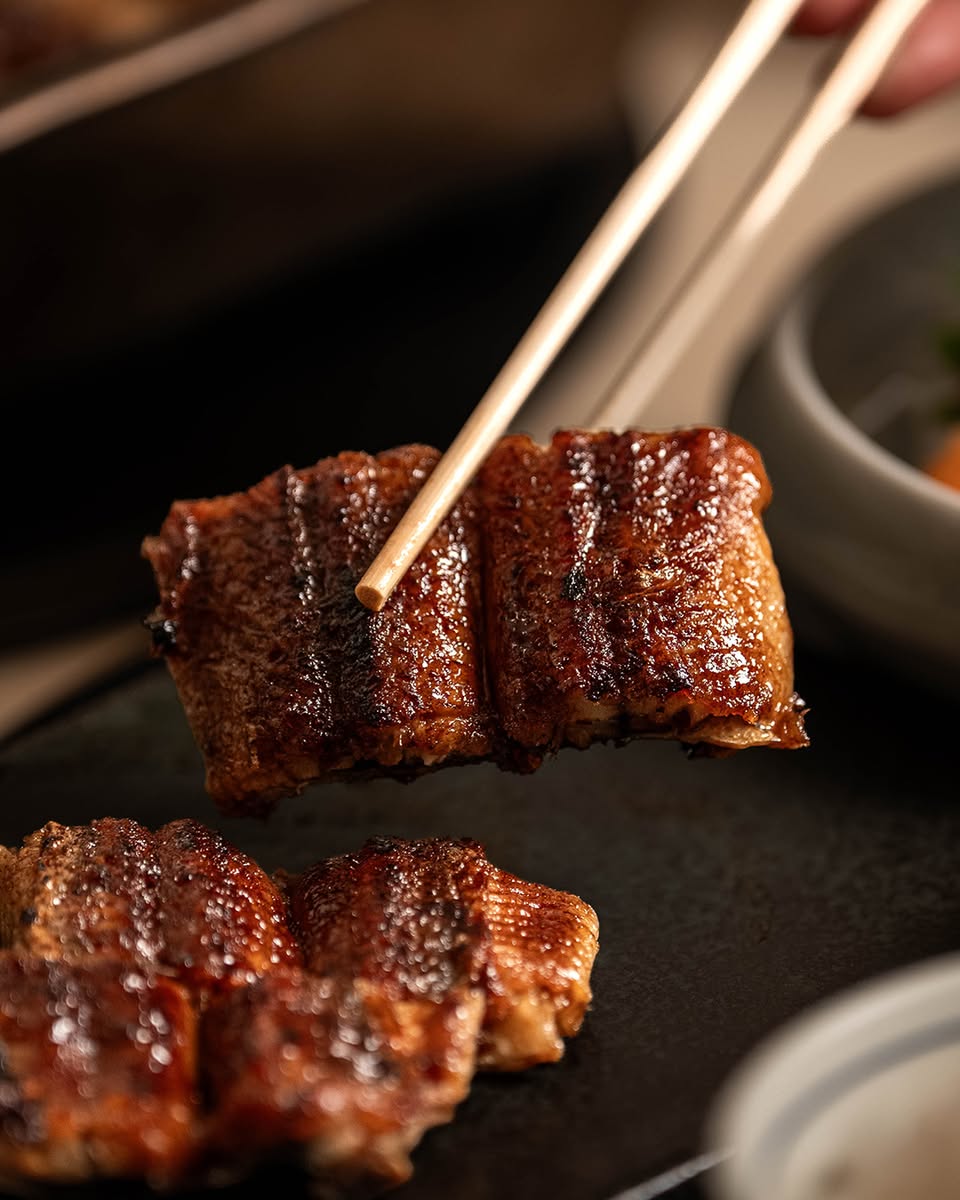 Grilled unagi held with chopsticks