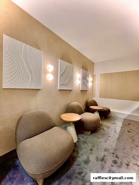 Aesthetic waiting area with textured art, plush seating, and modern lighting.