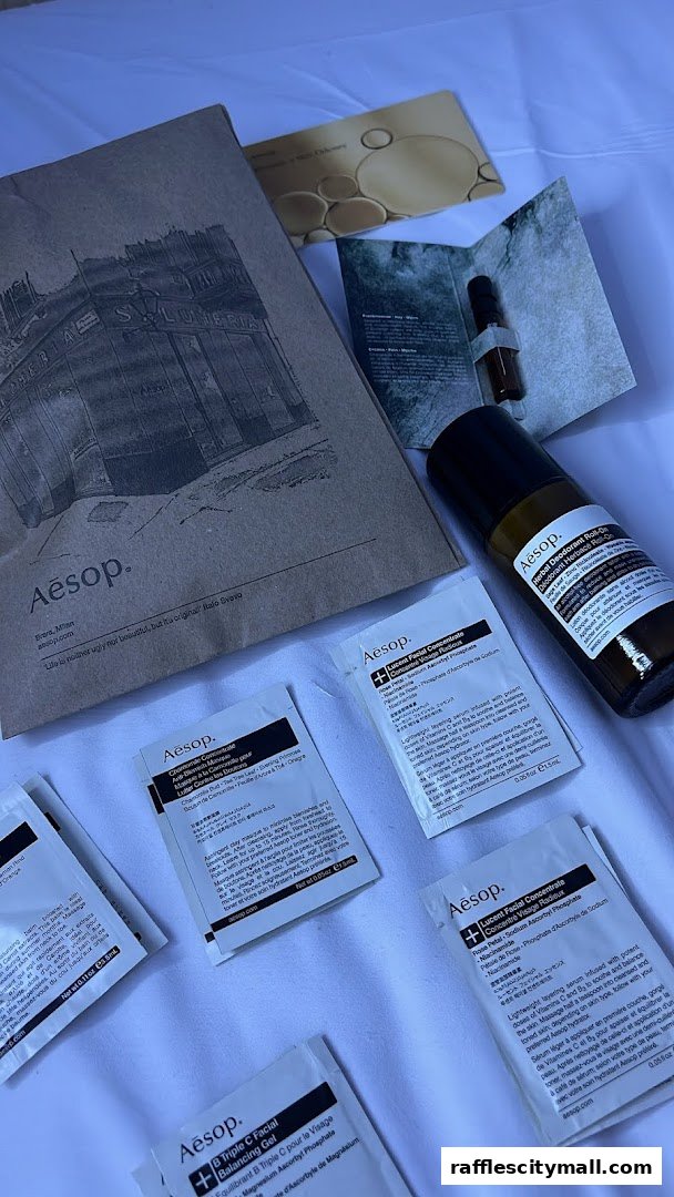 An assortment of Aesop skincare products, including sample sachets and a rollerball bottle.