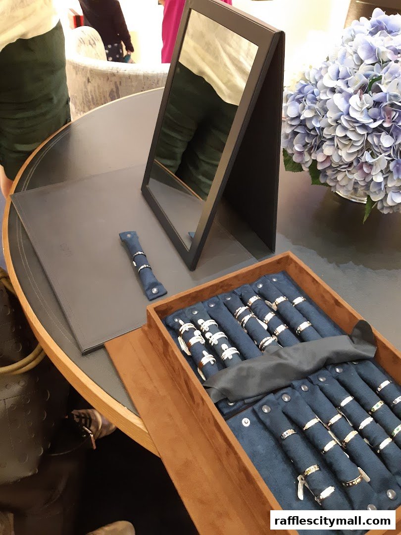 A display of rings in a jewelry store, with a mirror and flowers.