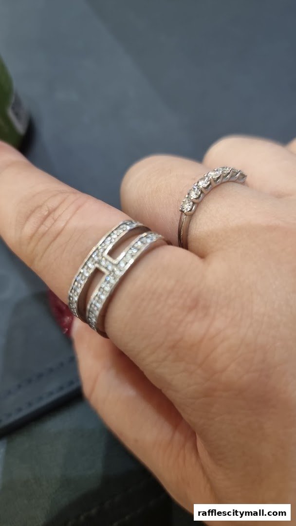Close-up of a hand wearing two sparkling rings, one with a geometric design.