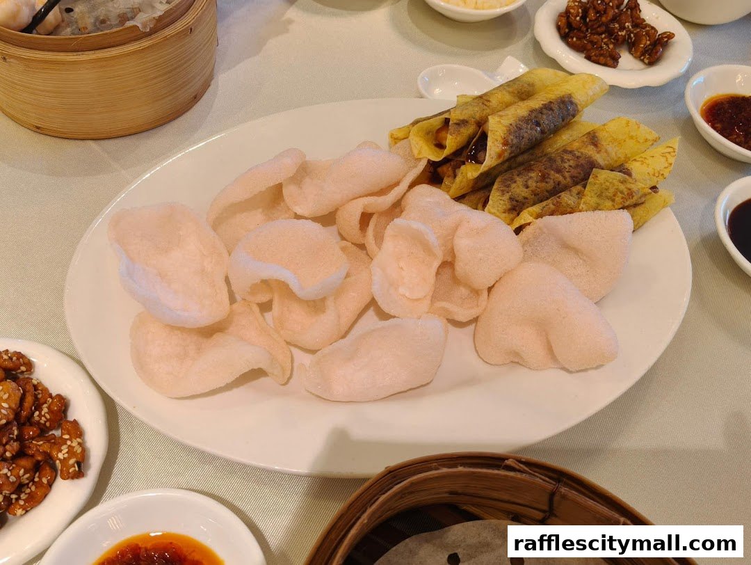 A plate of crispy prawn crackers and Peking duck rolls served with dipping sauces.