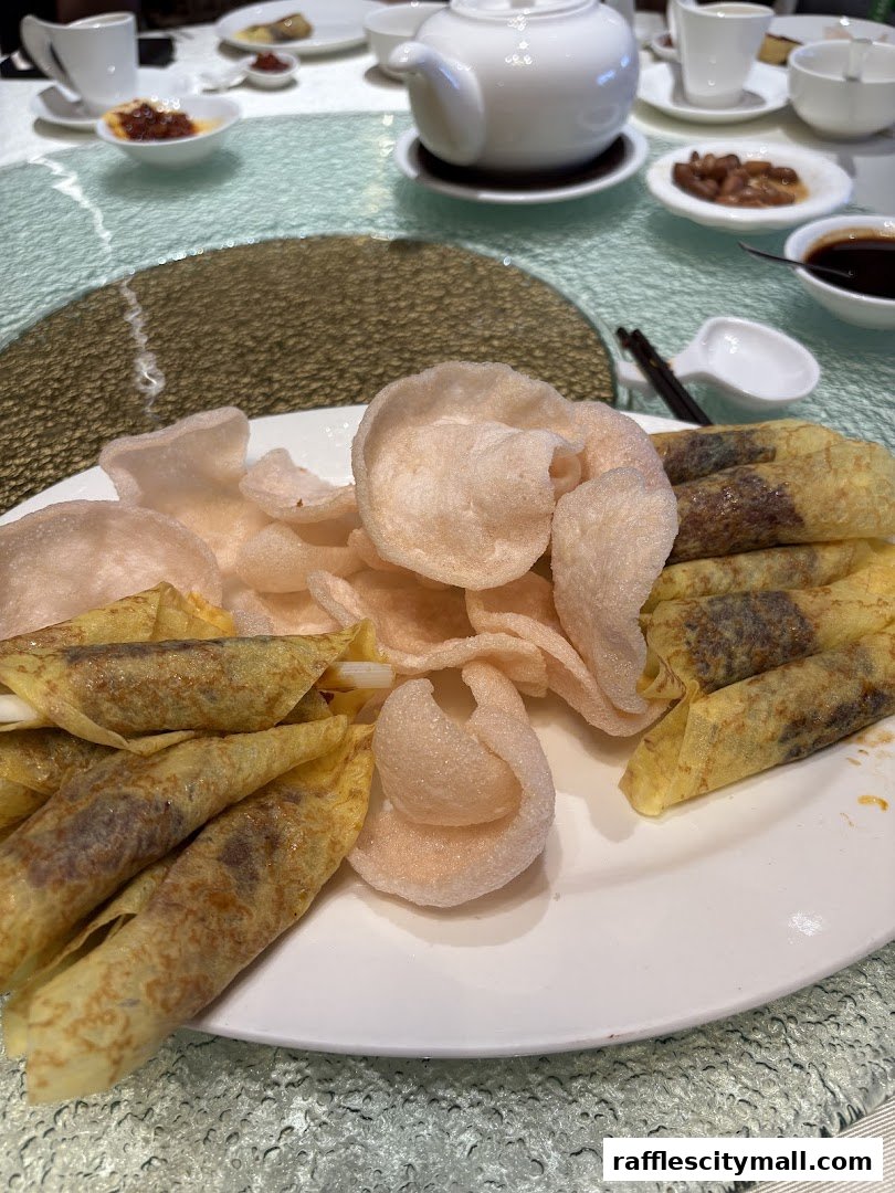 A plate of spring rolls and prawn crackers served at a restaurant.