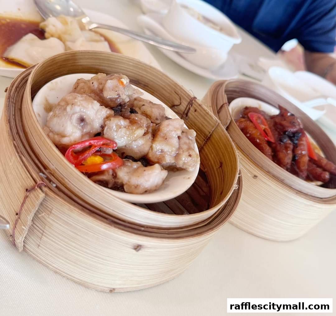Two bamboo steamers filled with delicious dim sum dishes, including chicken feet and dumplings.