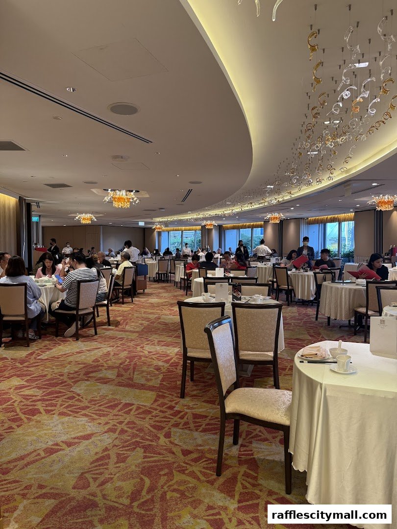 Interior view of a spacious restaurant with many tables and diners, featuring elegant decor.