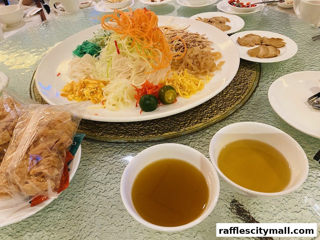 A beautifully presented Yu Sheng dish with various colorful ingredients and dipping sauces.