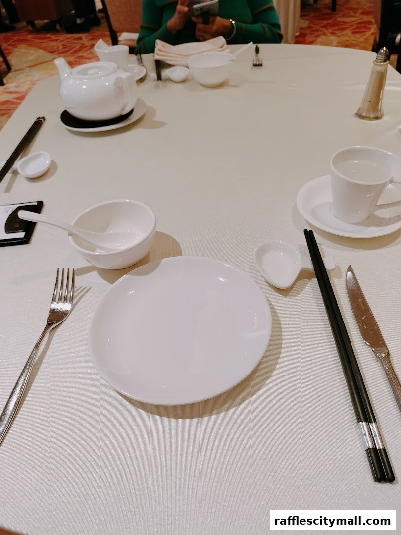 A table setting at Asia Grand Restaurant with place settings, teapot, and cups.