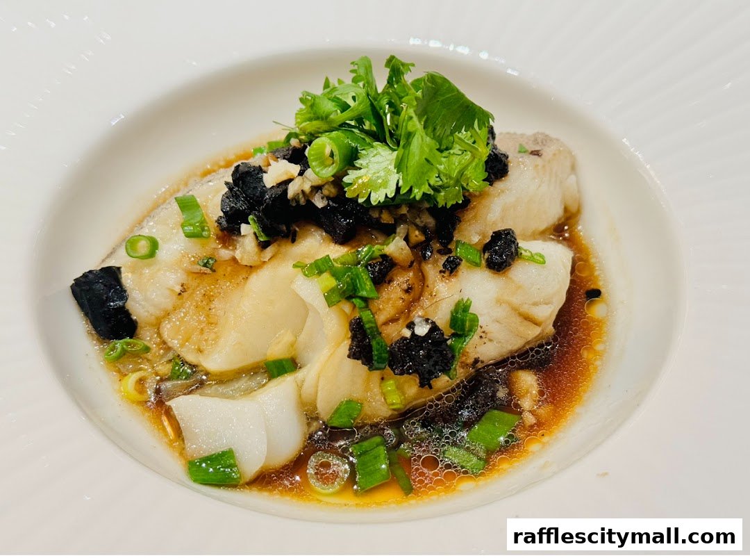 A close-up of a delicious steamed fish dish with black beans, garlic, and scallions.