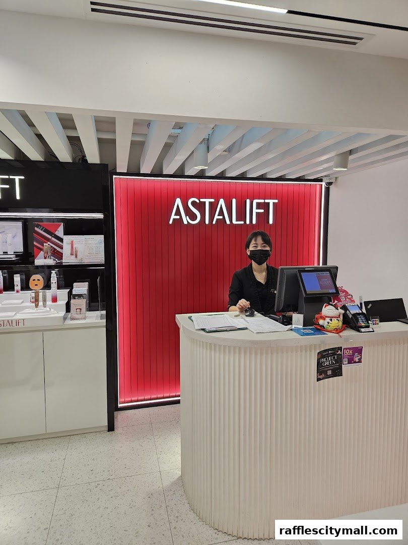 A smiling employee stands behind the counter at Astalift, a beauty store.