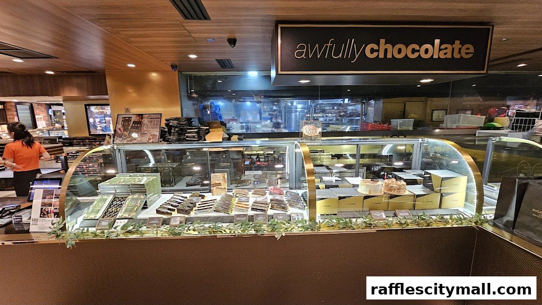 A display counter filled with various chocolate cakes and gift boxes at Awfully Chocolate.