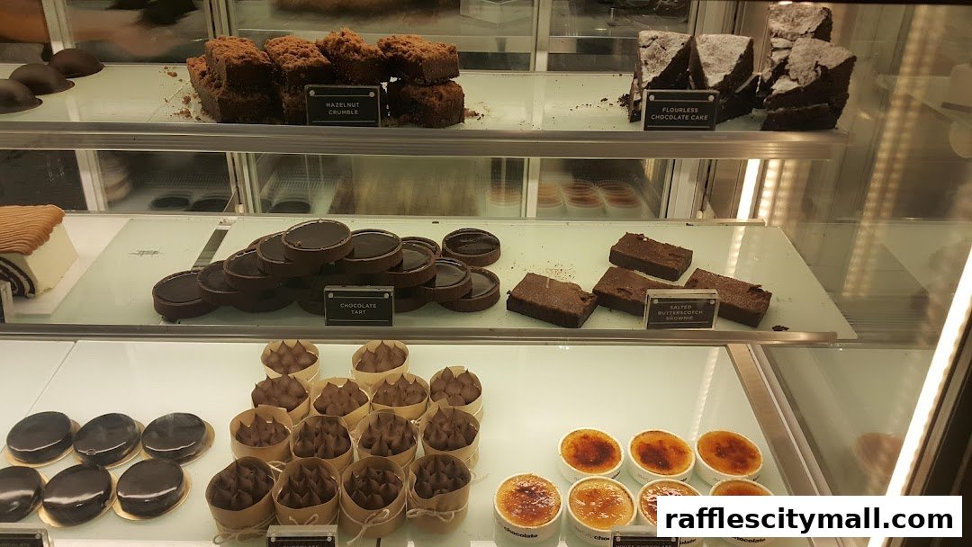 A display case filled with various chocolate desserts, including tarts, brownies, and crème brûlée.