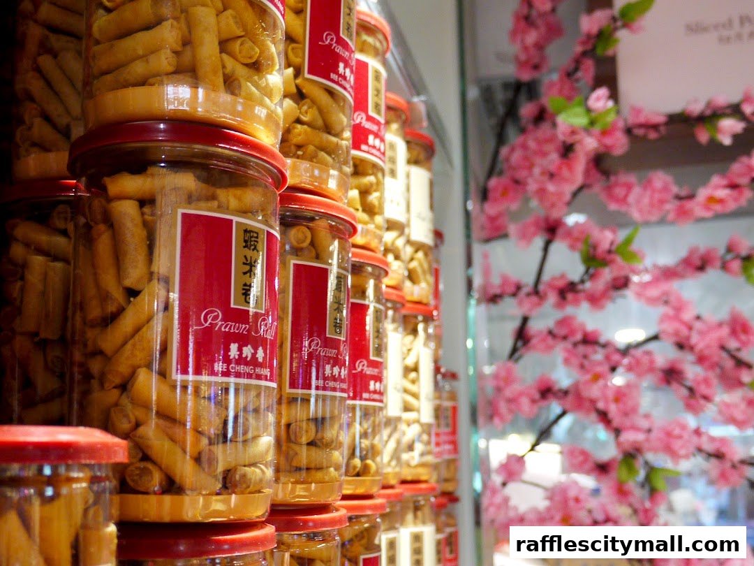 Jars of Prawn Rolls from Bee Cheng Hiang displayed with decorative pink flowers.