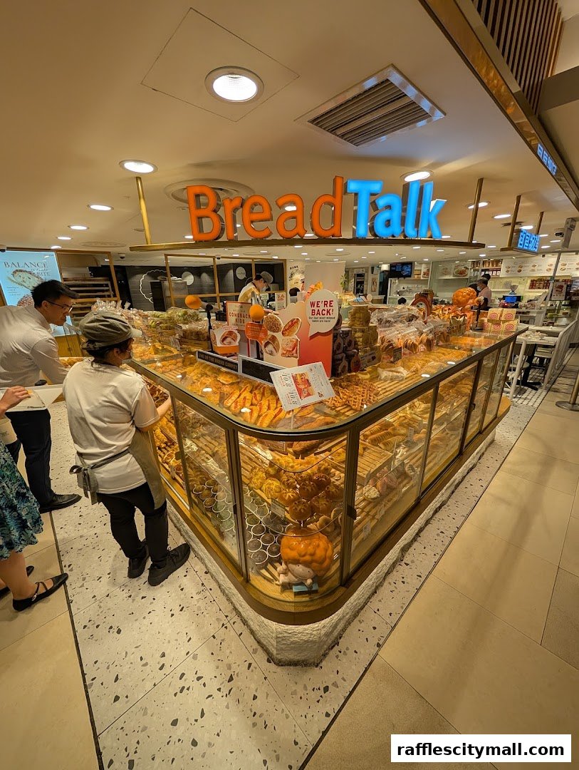 A BreadTalk bakery display filled with various fresh breads and pastries, with customers browsing.