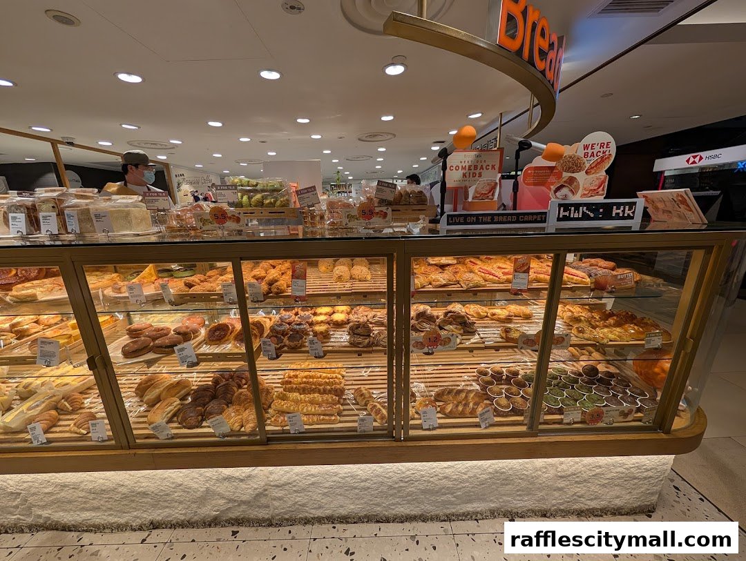 A display case filled with a variety of freshly baked breads, pastries, and cakes at BreadTalk.