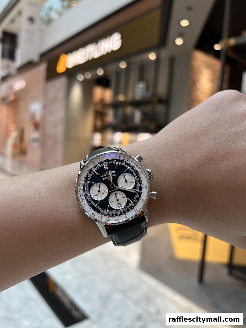 A person wears a Breitling Navitimer watch in front of the Breitling boutique.