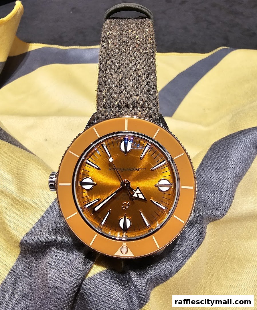 A close-up shot of a Breitling Superocean watch with an orange dial and a textured strap.