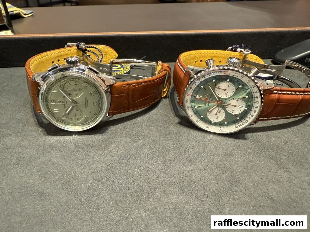 Two luxury Breitling watches with brown leather straps are displayed on a textured surface.