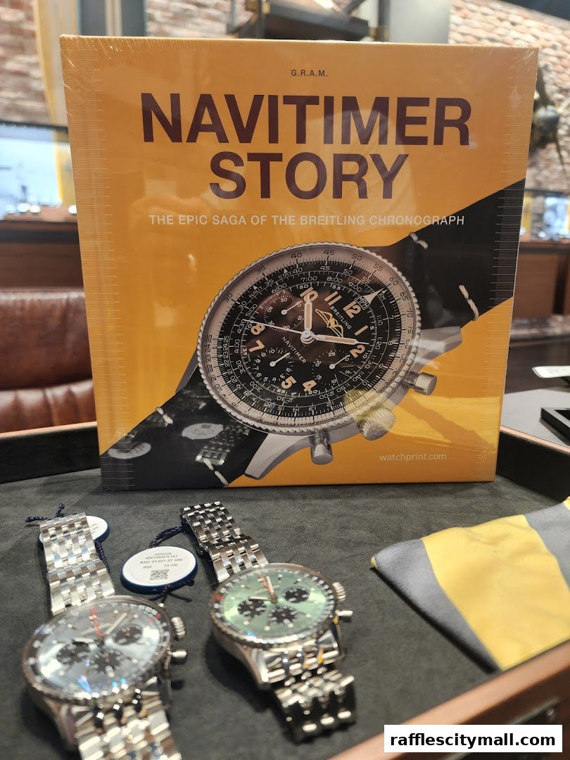 A Breitling Navitimer Story book displayed with two Breitling watches.