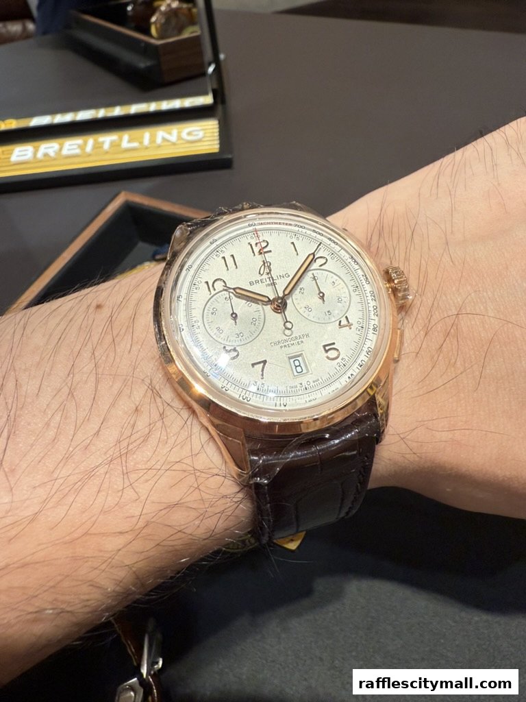 A close-up of a Breitling Chronograph Premier watch on a wrist with a dark leather strap.