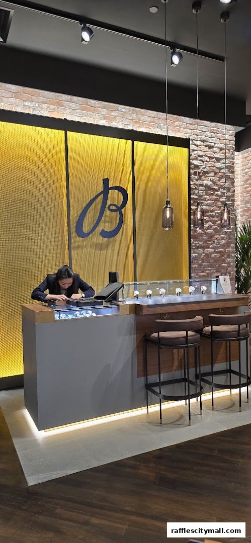 A woman works at a Breitling boutique counter with watches displayed in a case.