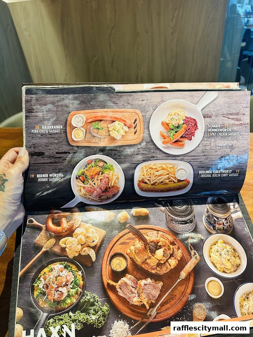 A menu from Brotzeit Raffles City showcasing various German sausages and pork dishes.