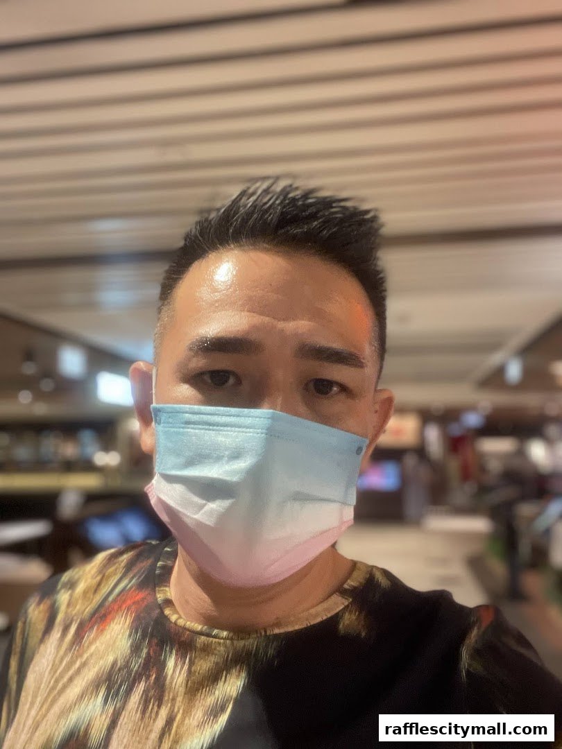 A person wearing a gradient face mask and a patterned shirt.