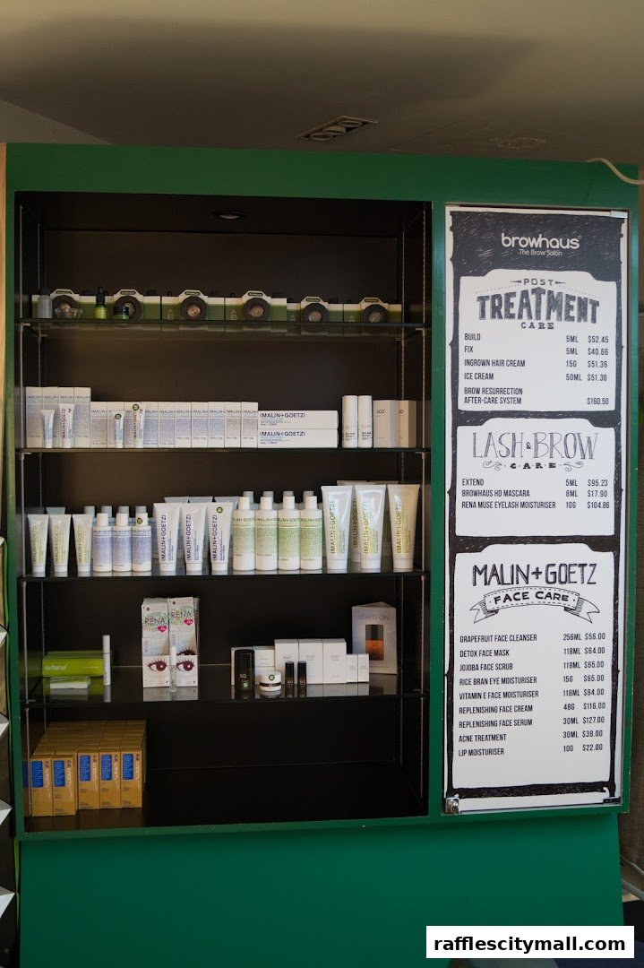 A display shelf with various skincare products and a price list for Browhaus services and Malin+Goetz products.