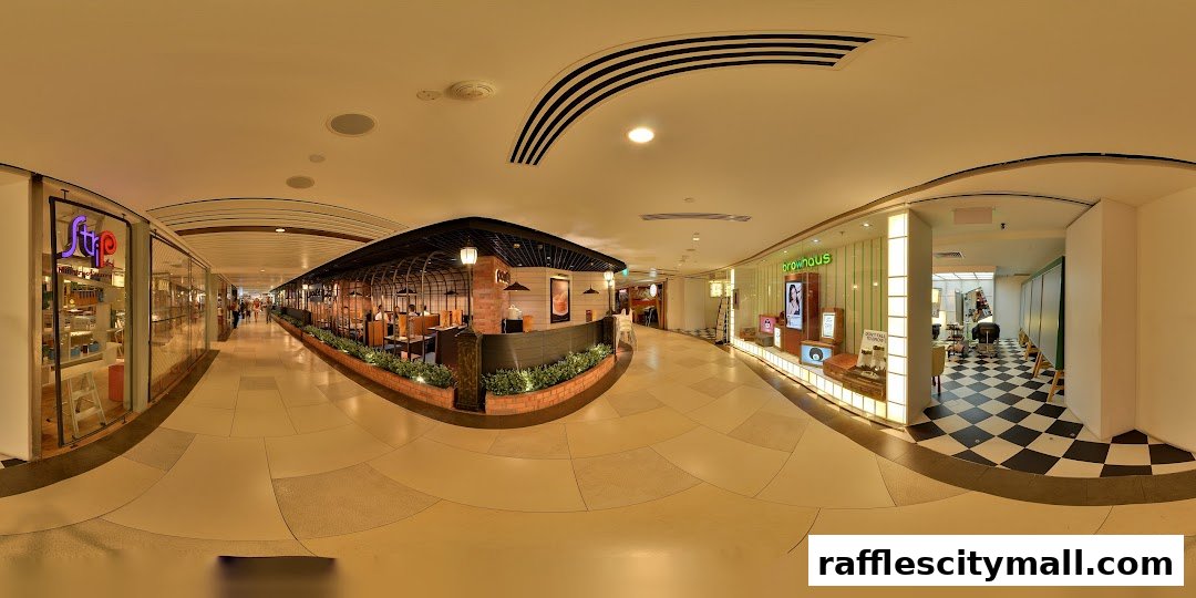 A panoramic view of a shopping mall corridor featuring several shops, including a beauty salon and a restaurant.