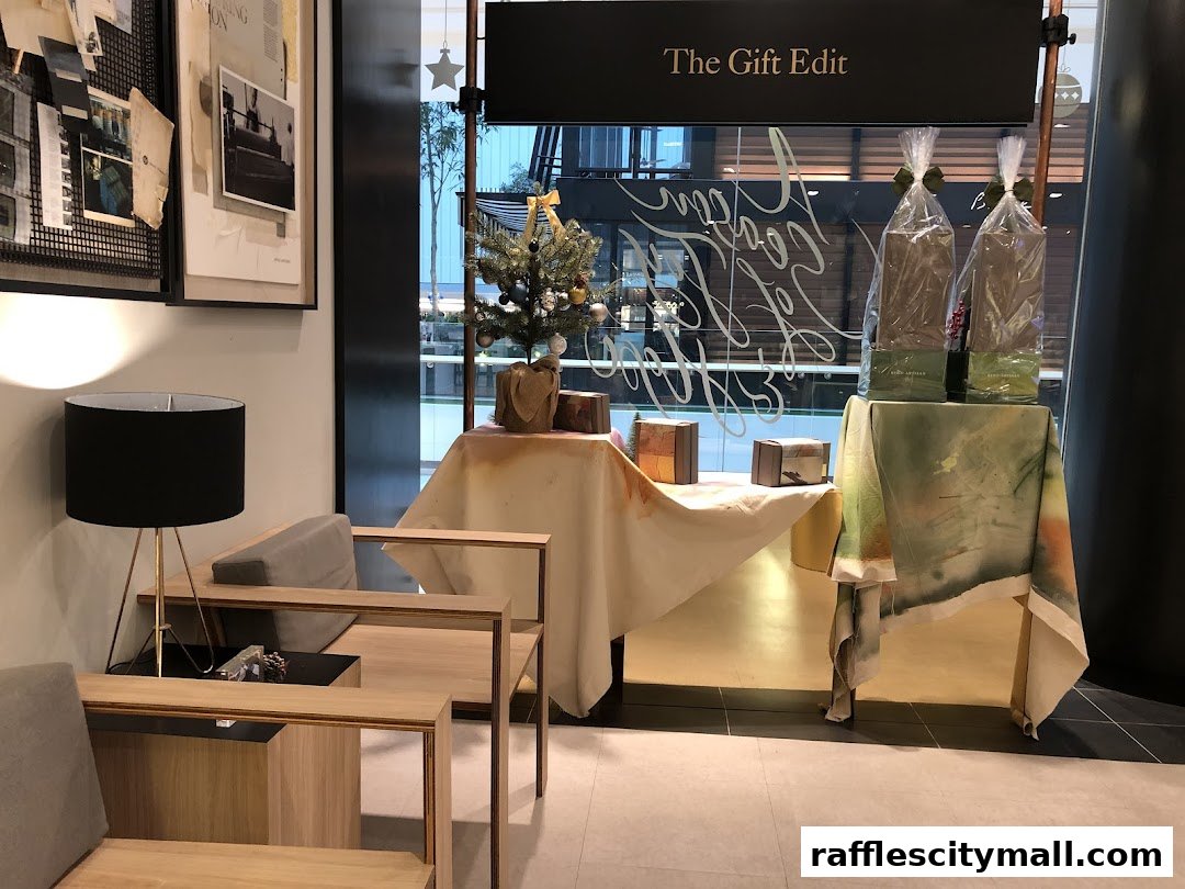 A shop interior with seating, a decorated Christmas tree, and gift-wrapped items.