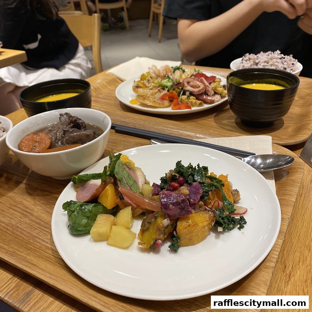 A close-up of a healthy meal with salad, stew, and soup served on wooden trays.