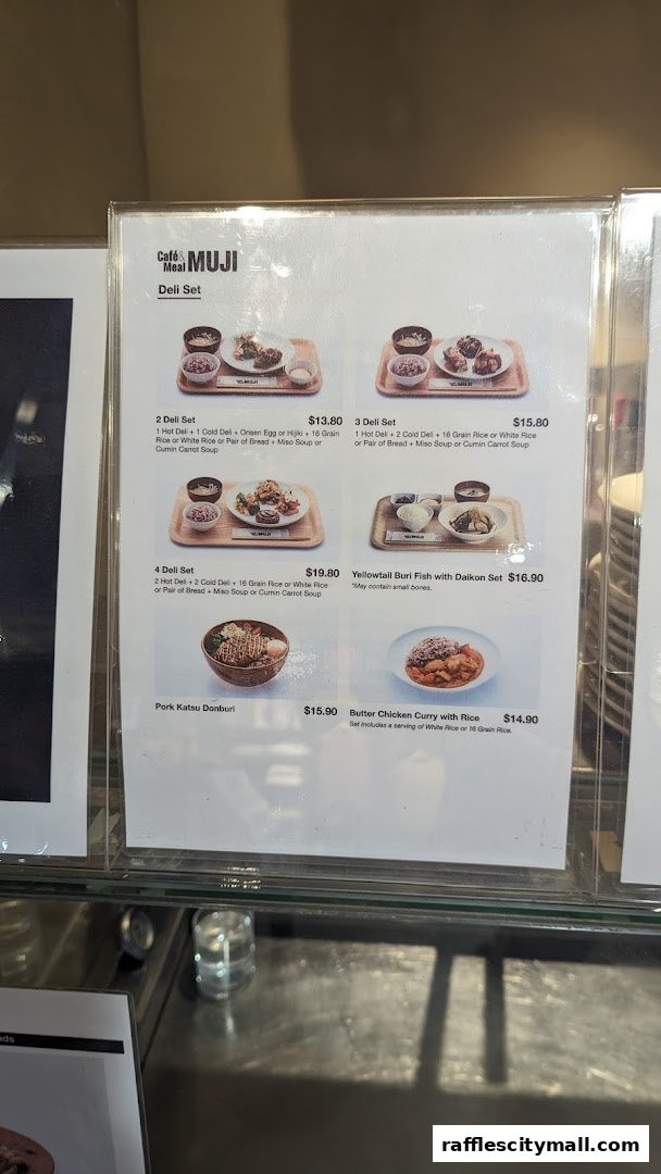 A menu display for CafeMeal MUJI featuring various deli sets and main dishes.
