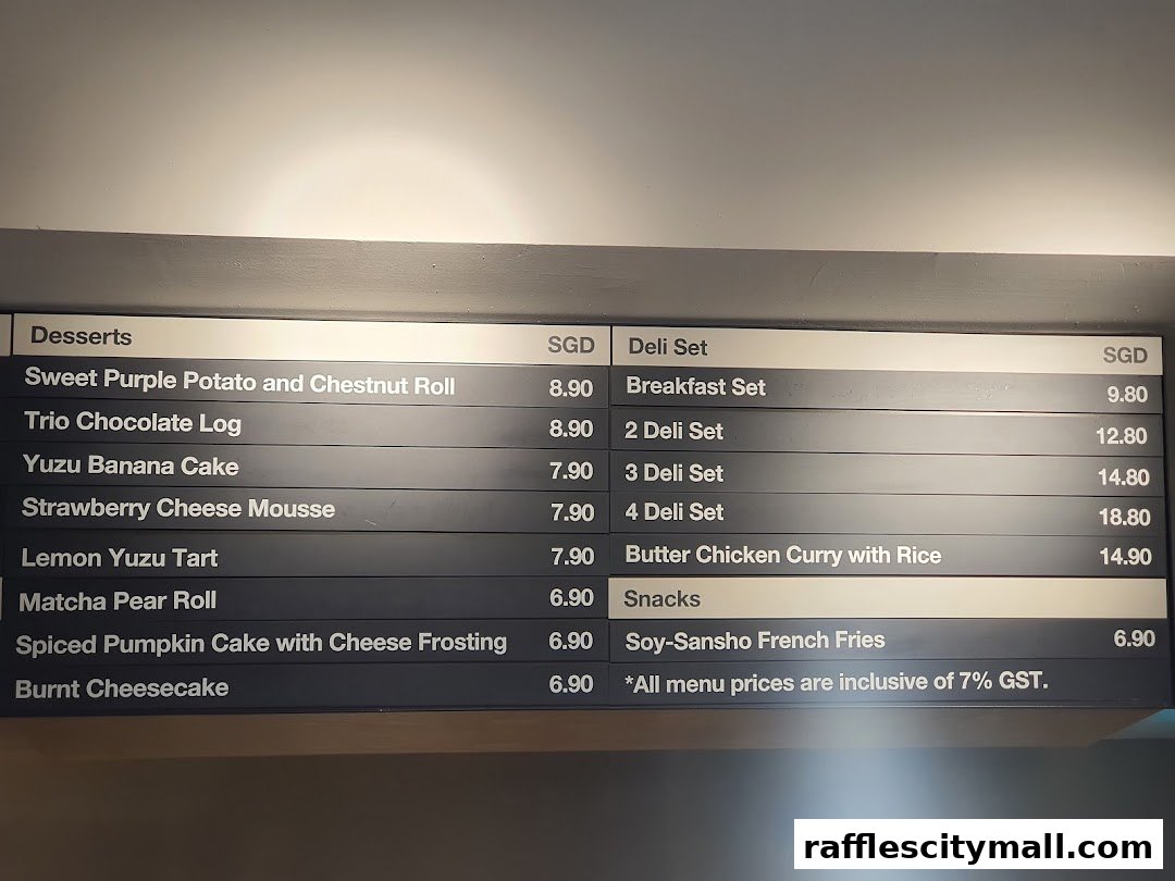 A menu board displaying desserts, deli sets, snacks, and prices at CaféMeal MUJI Raffles City.