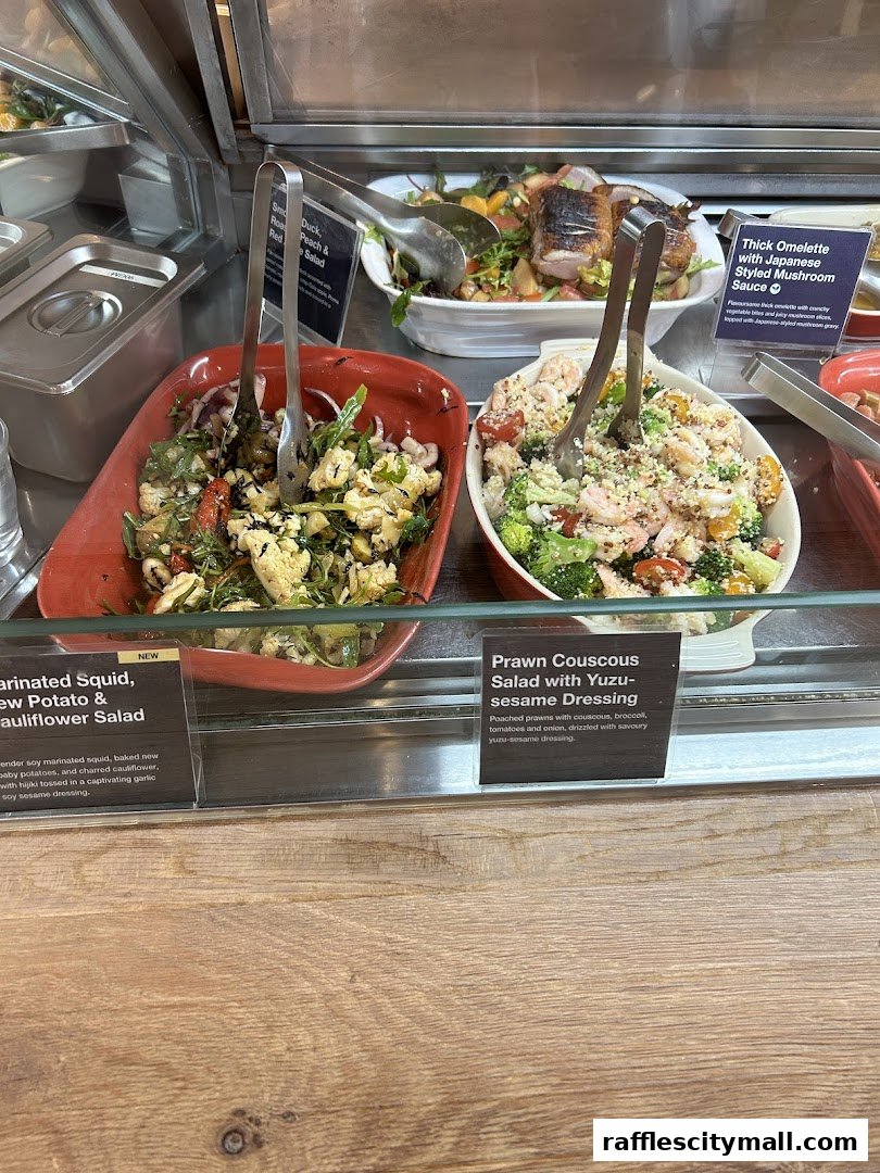 Display of fresh salads and an omelette at a food counter.
