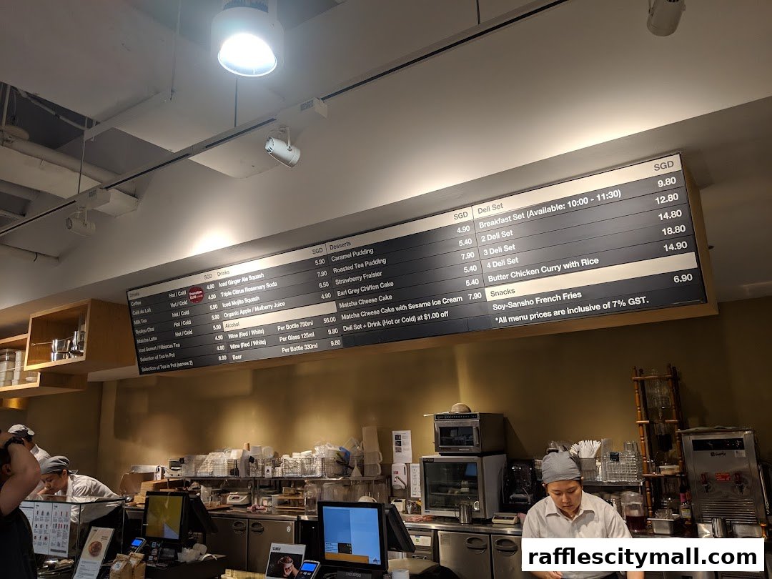 A menu board displaying drinks, desserts, deli sets, snacks, and alcohol at CafeMeal MUJI Raffles City.