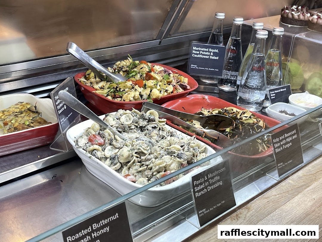 A display of various salads and bottled water at a food counter.
