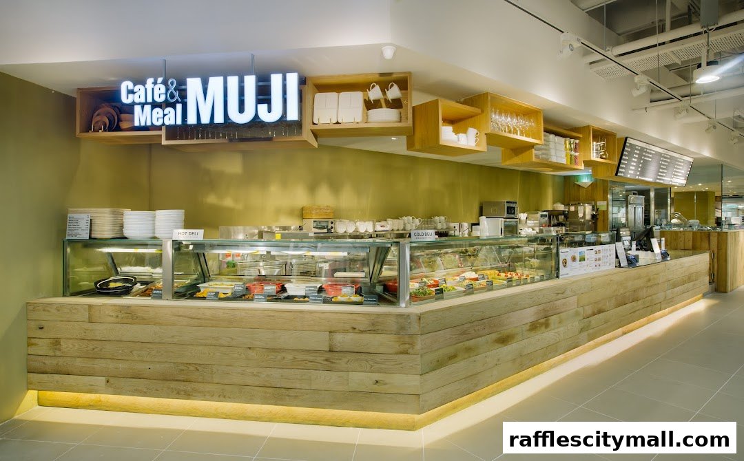 A well-lit cafe counter with a display of fresh food and a prominent MUJI sign.