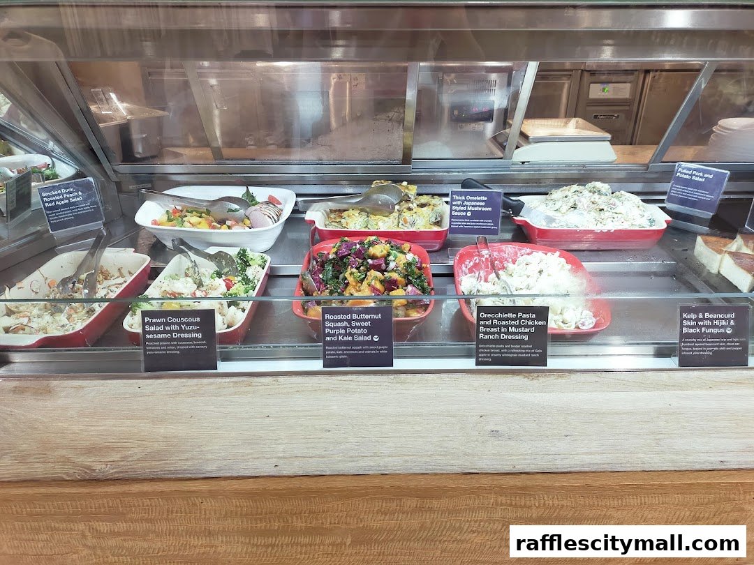A display case filled with various salads and prepared dishes at a cafe.