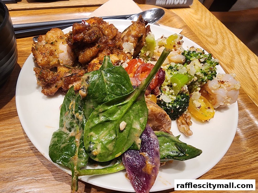 A plate of food with fried chicken, salad, and quinoa salad with shrimp.