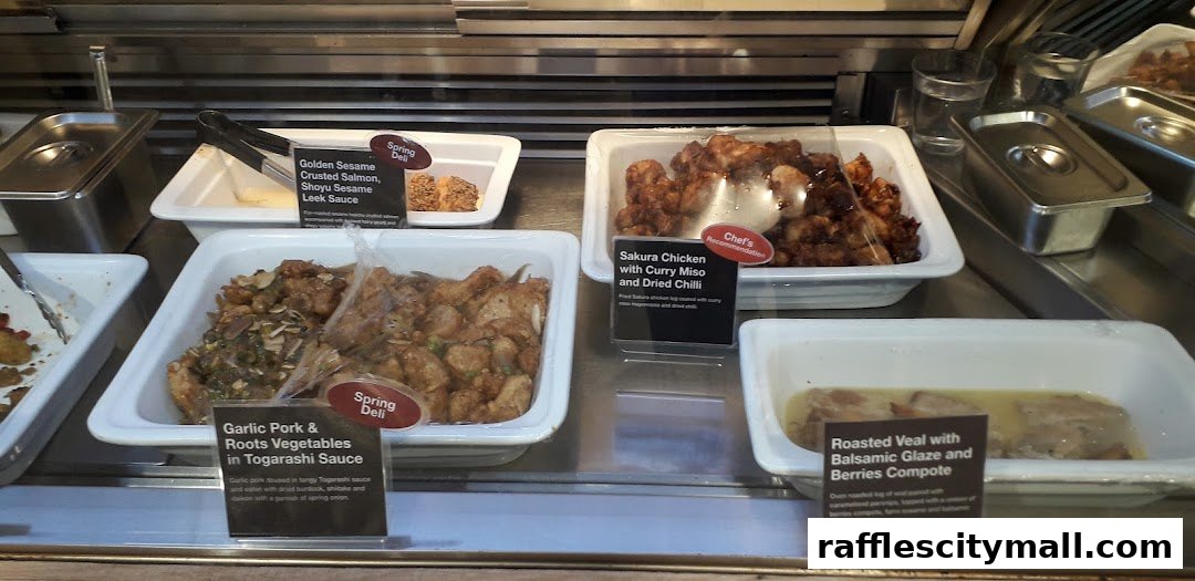 A display of various prepared food dishes in white trays at a deli counter.