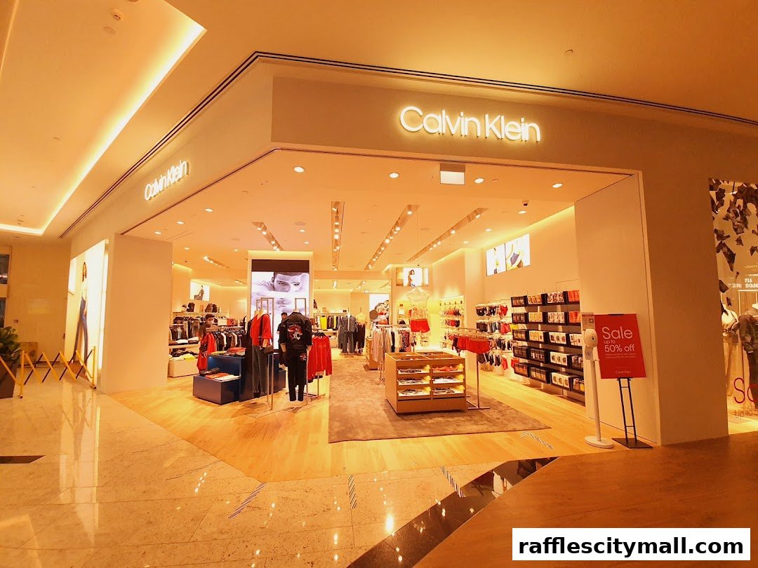 The exterior of a Calvin Klein store with clothing displays and a sale sign.