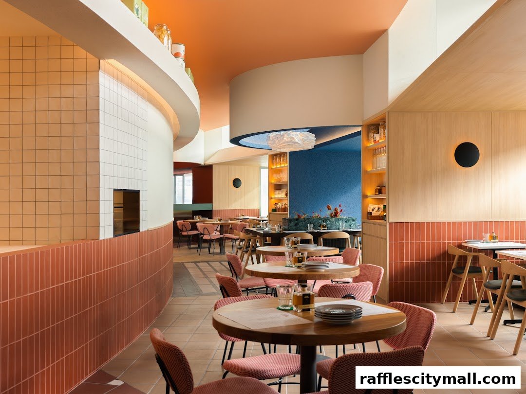 Interior view of a modern restaurant with colorful walls, tables, and chairs.