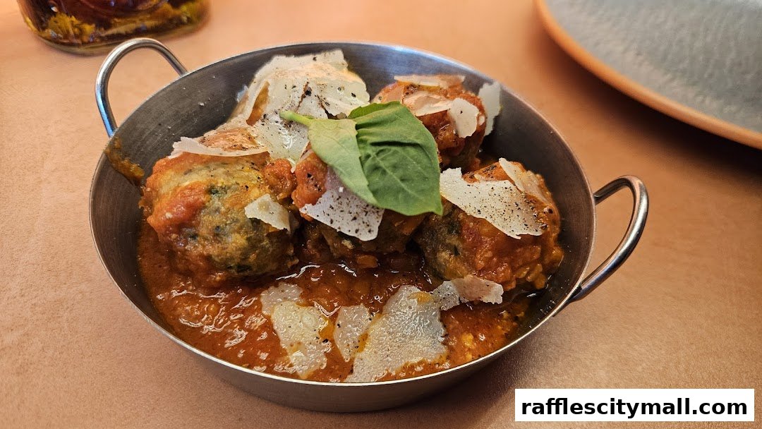 A close-up of delicious meatballs in a rich tomato sauce, topped with cheese and basil.