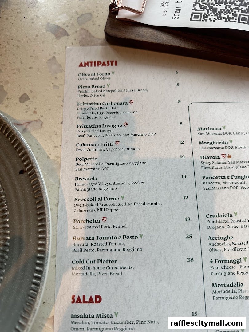 A close-up view of a restaurant menu featuring antipasti and salad sections.