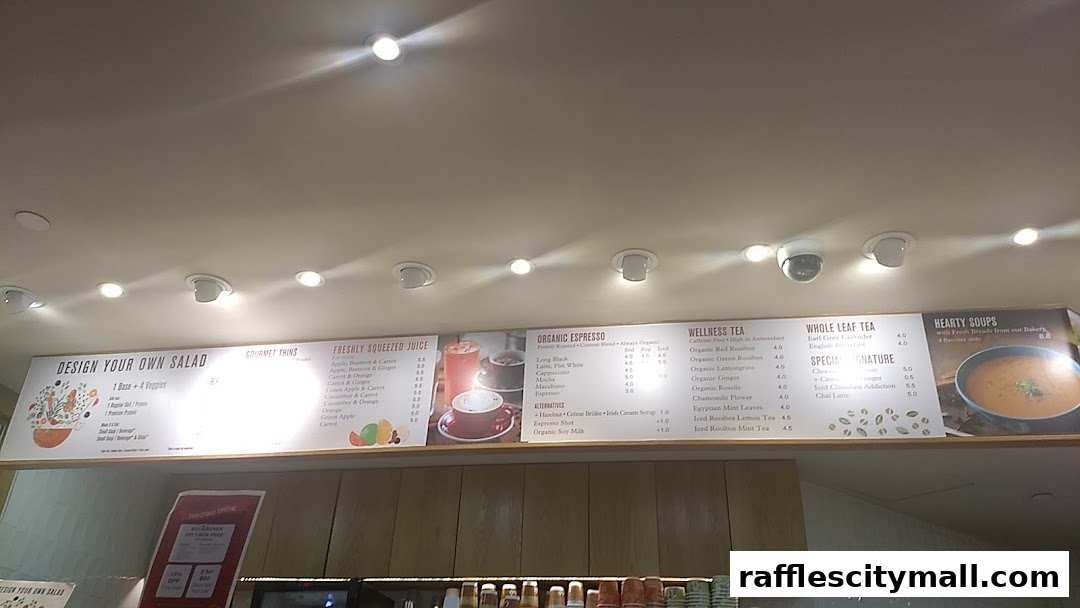 A menu board displaying salads, juices, espresso drinks, teas, and soups.