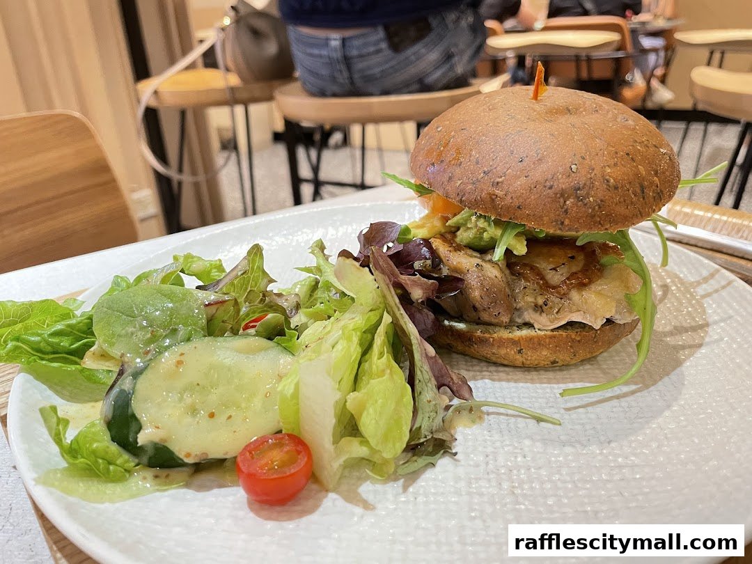 A delicious burger with a side salad on a white plate at Cedele Bakery Kitchen.