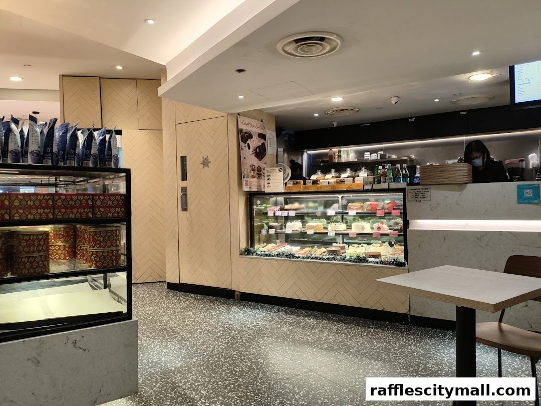 Interior of Cedele Bakery Kitchen with display cases of cakes and pastries, and a seating area.