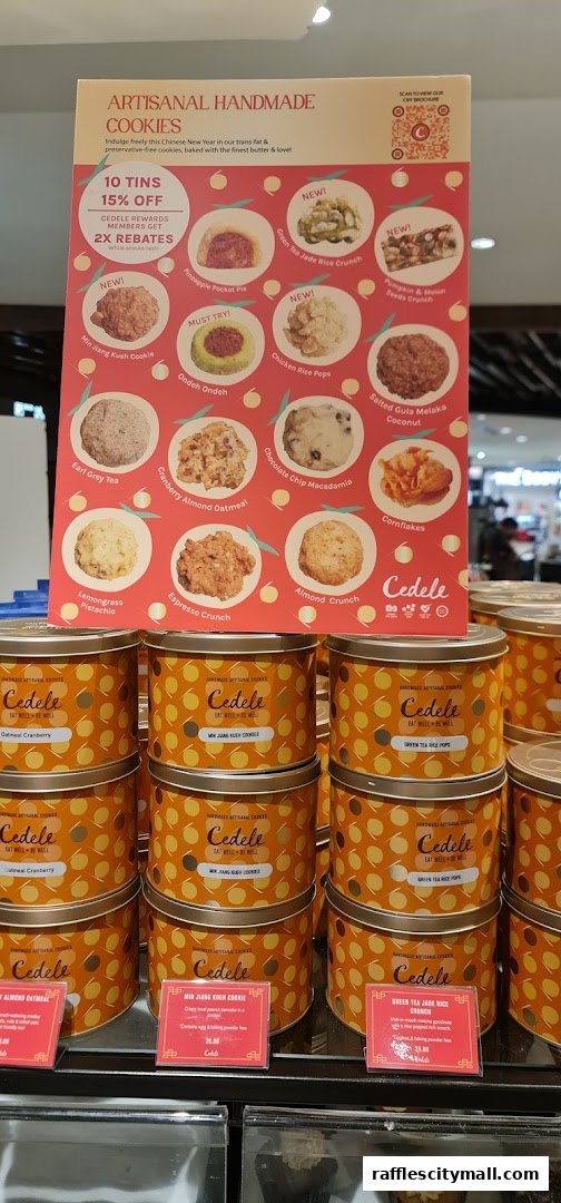 A display of Cedele artisanal handmade cookies in decorative tins, with a promotional poster.