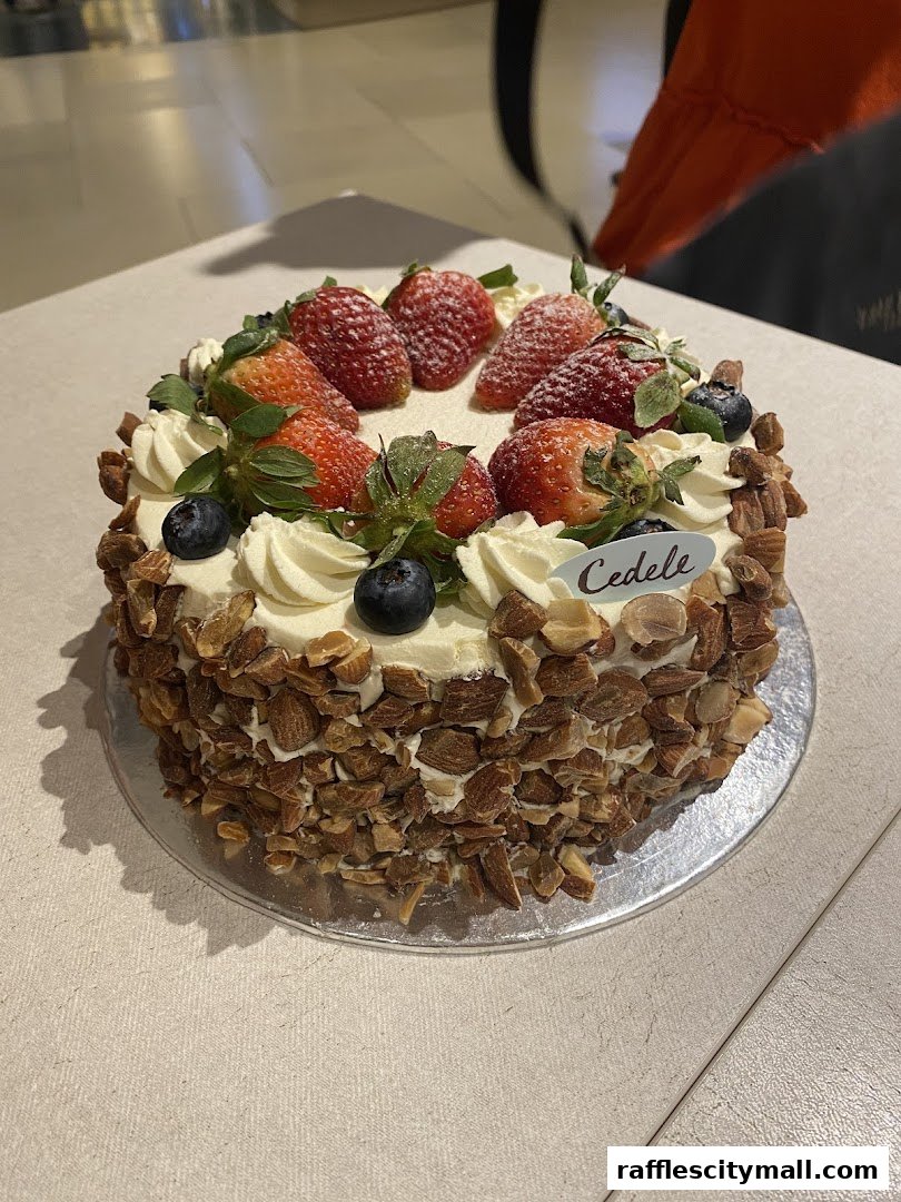 A beautifully decorated cake with strawberries, blueberries, and almonds from Cedele Bakery Kitchen.